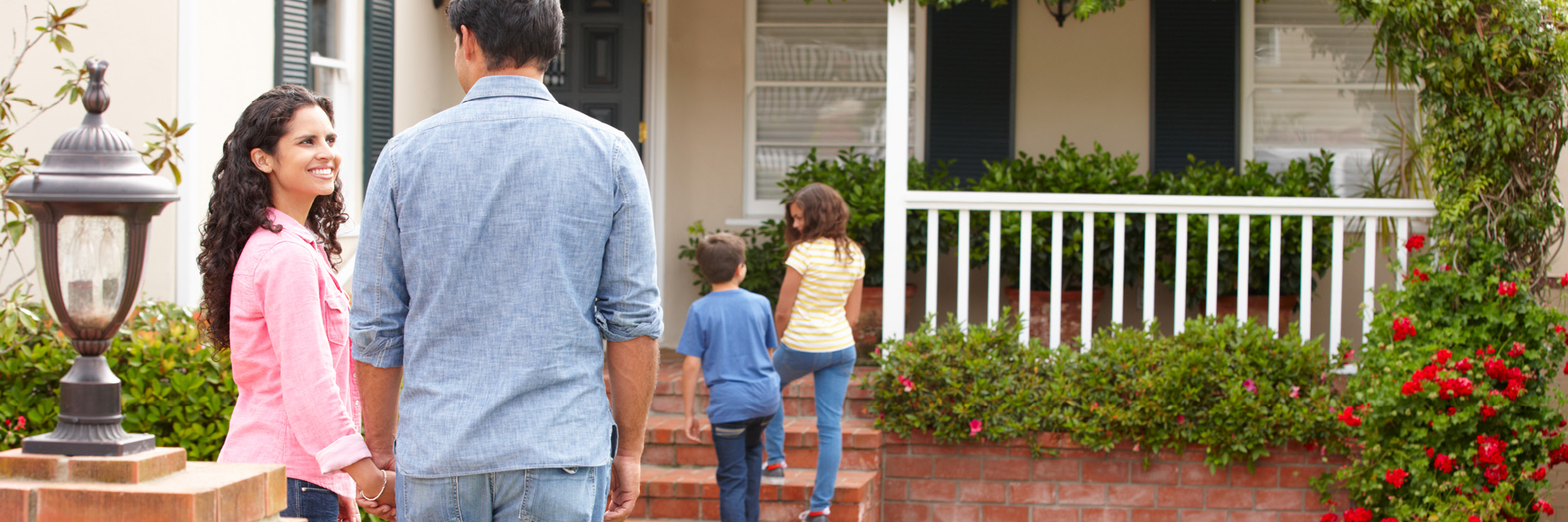 Mother and father with two children entering their new house